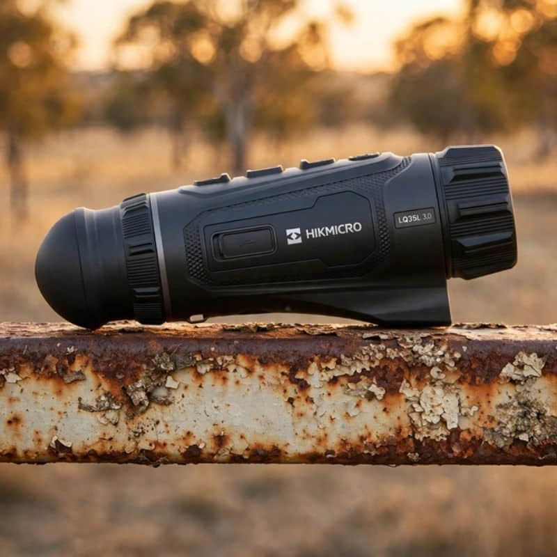 Hikmicro Lynx LQ35L 3.0 Thermal Monocular on top of a Rusty Farm Gate Rail