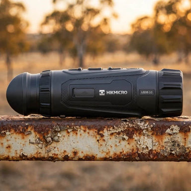 Hikmicro Lynx LQ35 3.0 Thermal Monocular on top of a Rusty Farm Gate Rail
